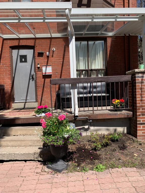a bench in front of a house with flowers at Pembroke suites in Toronto