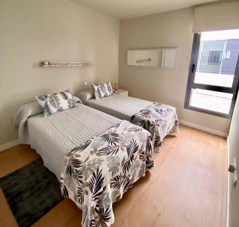 a bedroom with two beds and a window at Apartamento Abades Playa & Relax in Abades