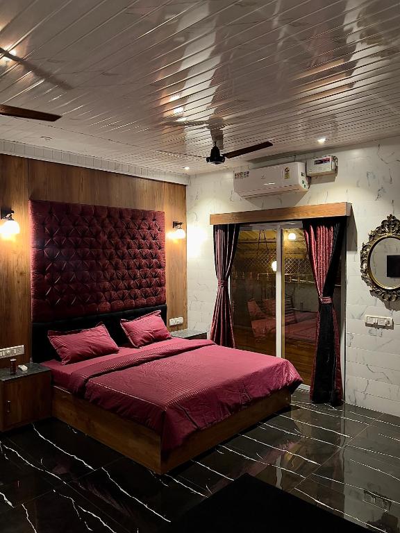 sypialnia z dużym łóżkiem z czerwonym zagłówkiem w obiekcie Imagine Love w mieście Lonavla