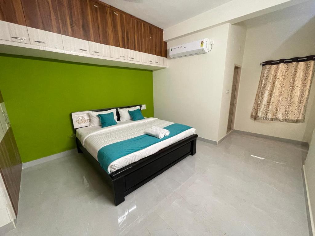 a bedroom with a bed with a green wall at Sun Home Stays - Spacious Rooms - New Property - Pleasant Location in Tirupati