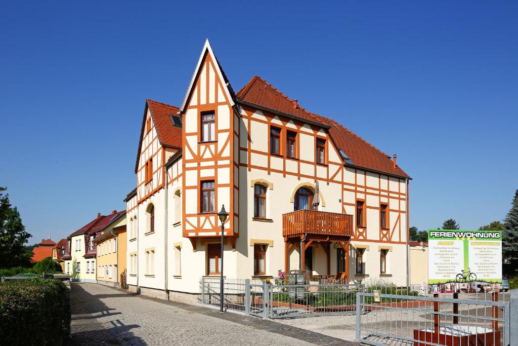 ein großes orangefarbenes und weißes Gebäude auf einer Straße in der Unterkunft Ferienwohnung Morgensonne am Kurpark in Bad Berka