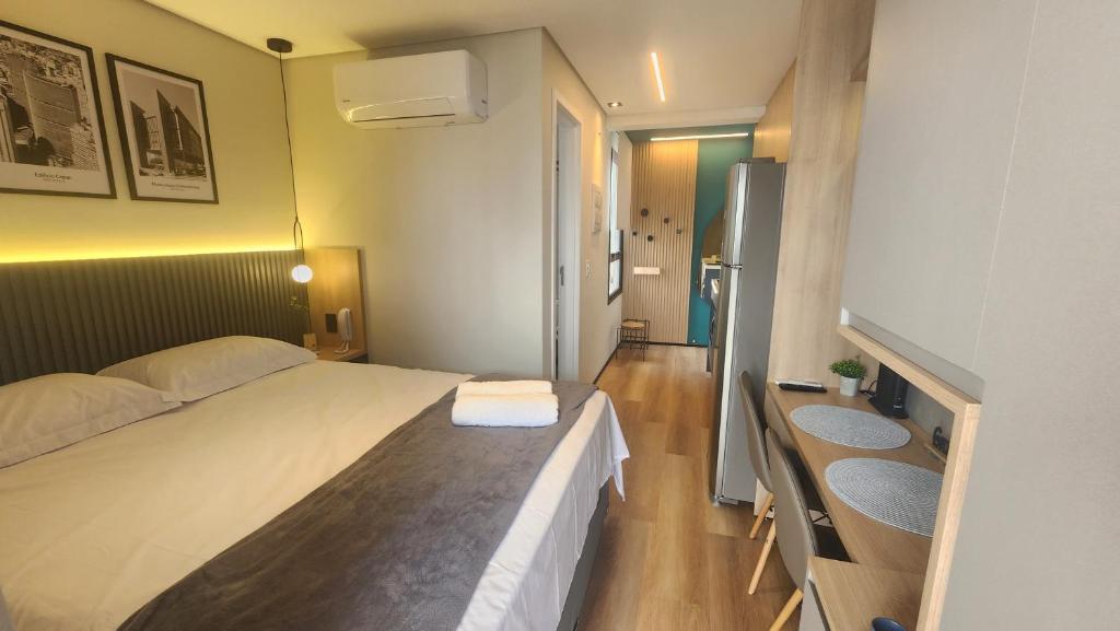 ein Schlafzimmer mit einem Bett und einem Waschbecken darin in der Unterkunft Studio Novo, aconchegante! in São Paulo