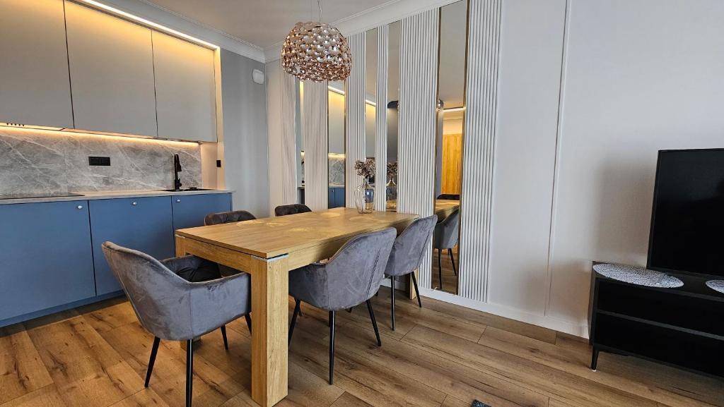 a dining room with a wooden table and chairs at Apartament Elegance, Metro, free parking in Warsaw