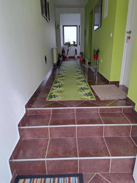 a hallway with a tile floor and green walls at Rooms Modrušan in Slunj
