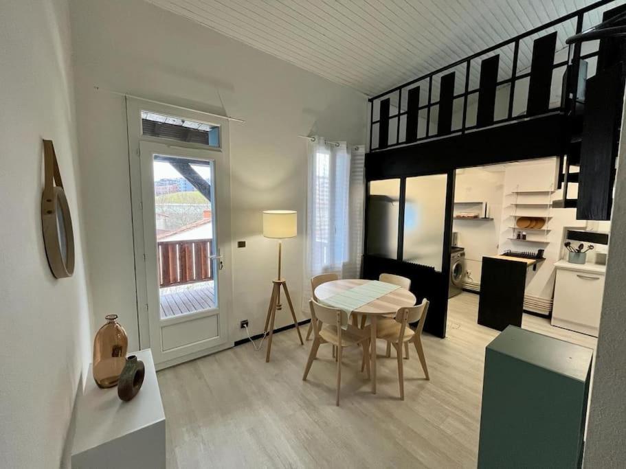 un salon avec une table et une cuisine dans l'établissement Joli T3 duplex Compans Cafarelli, à Toulouse