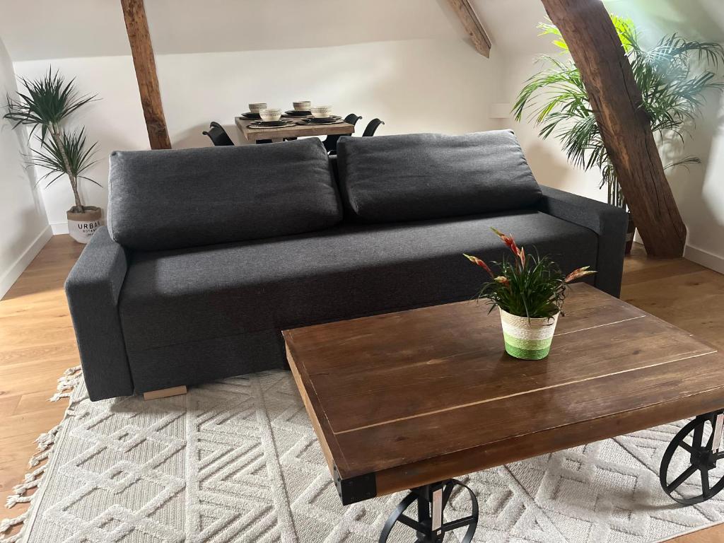 a black couch sitting in a living room with a coffee table at Appartement Aéroport Orly in Athis-Mons