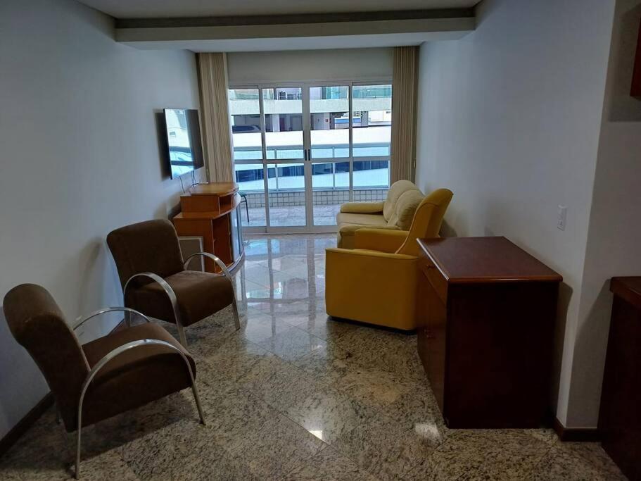 a living room with a yellow couch and chairs at Casa do Vô Luiz in Vila Velha