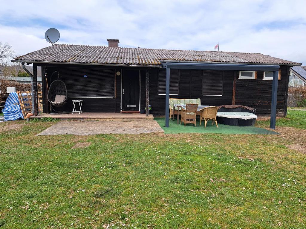 ein Haus mit einer Terrasse, einem Tisch und Stühlen in der Unterkunft Ferienhaus am Edersee-scheid in Waldeck