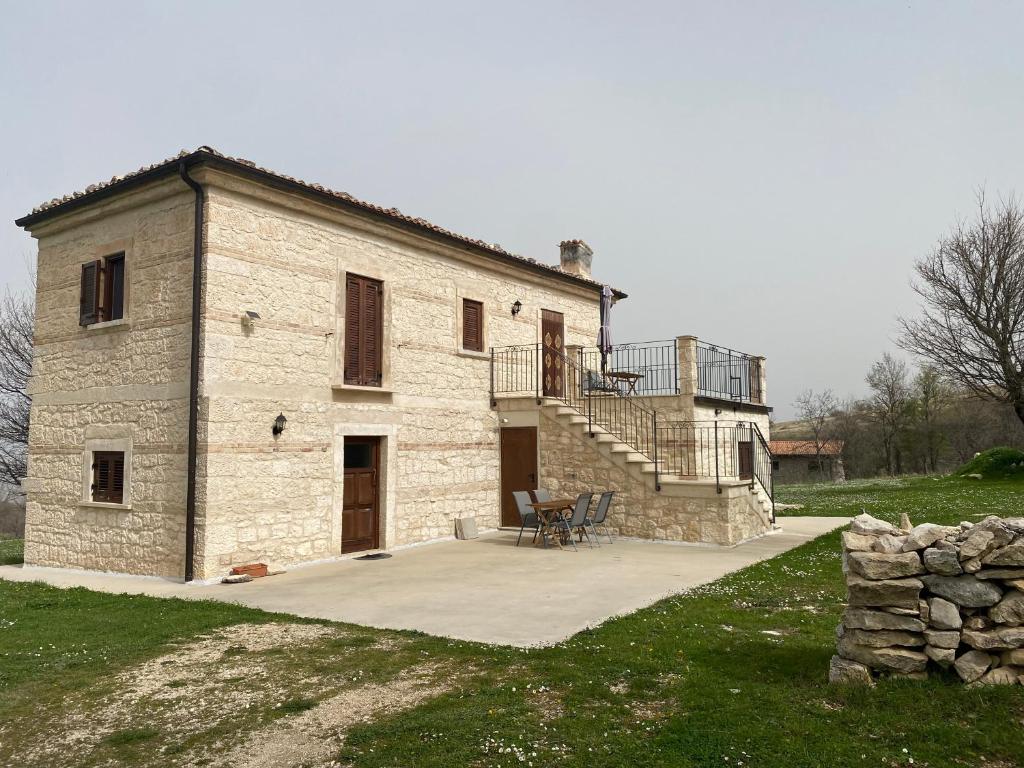 a large stone building with a staircase and a patio at Pezzelelle in Roccamorice