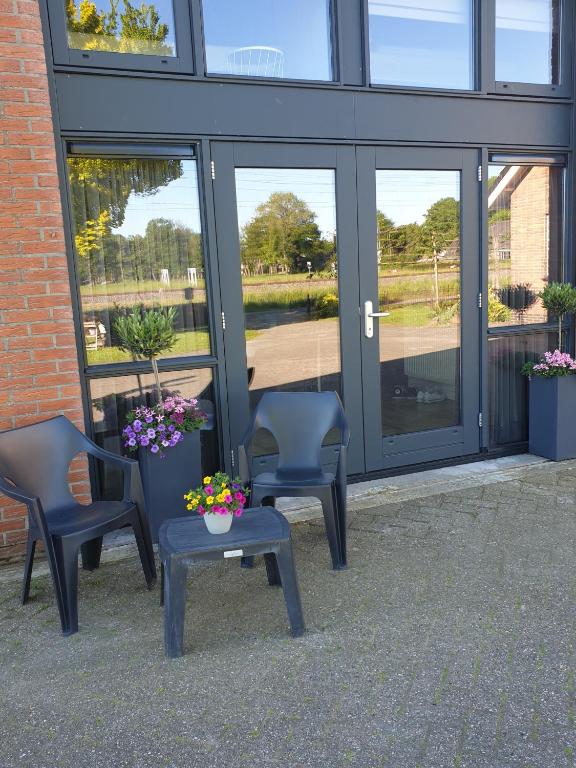 two chairs and a table in front of a building at De Boalder in Hardenberg