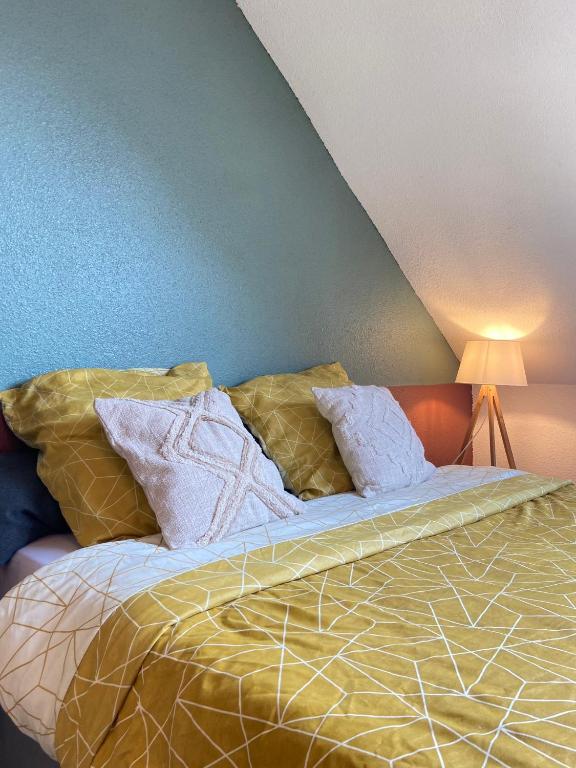 un lit avec des oreillers dessus dans une chambre dans l'établissement Bel appartement 2 pièces, à Soufflenheim