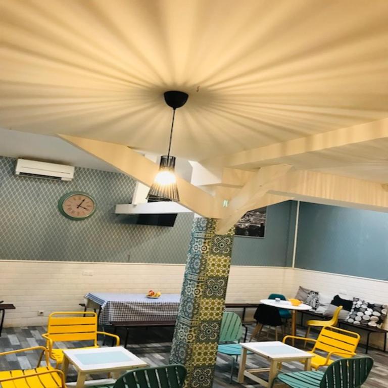 une salle à manger avec des chaises jaunes et un plafond dans l'établissement trendy hostel, à Ivry-sur-Seine