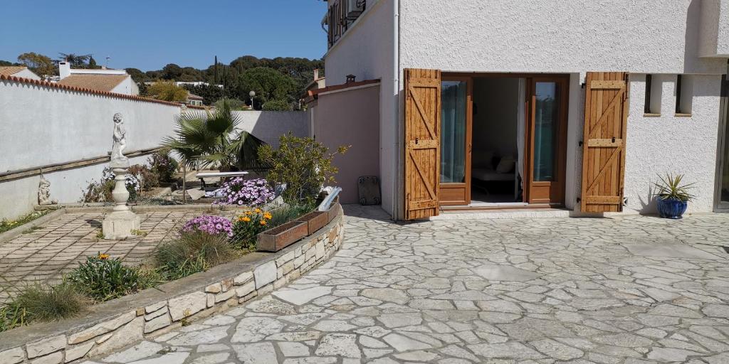 une maison avec un patio fleuri devant dans l'établissement Appartement proche plages et commerces, à La Ciotat
