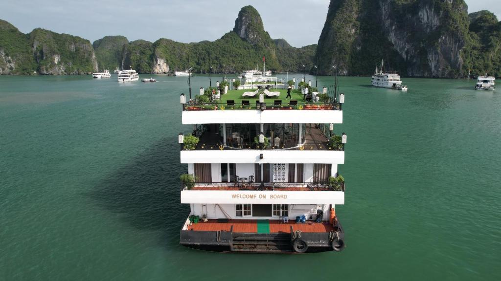a large boat in the water with other boats at Hạ Long Aqua Legend Cruise in Ha Long