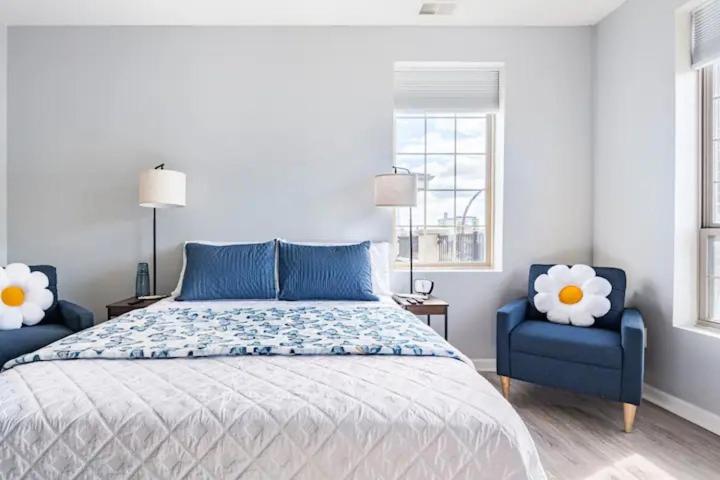 a bedroom with a bed and two blue chairs at Blue Oasis in Dearborn