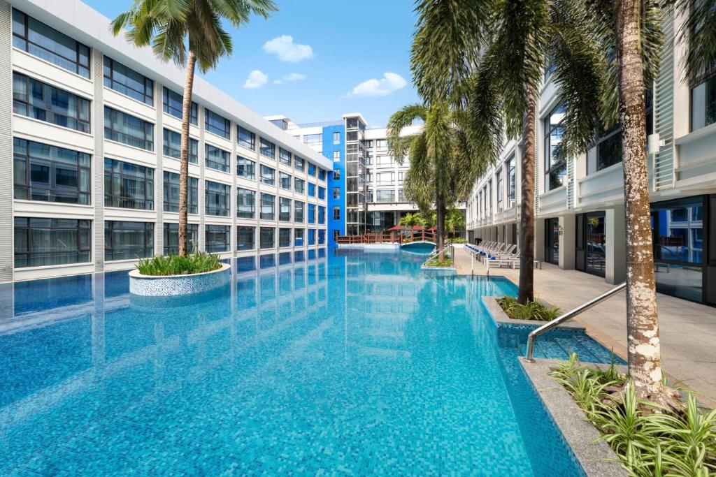 - une piscine à débordement dans un bâtiment avec des palmiers dans l'établissement Four Points by Sheraton Boracay, à Boracay