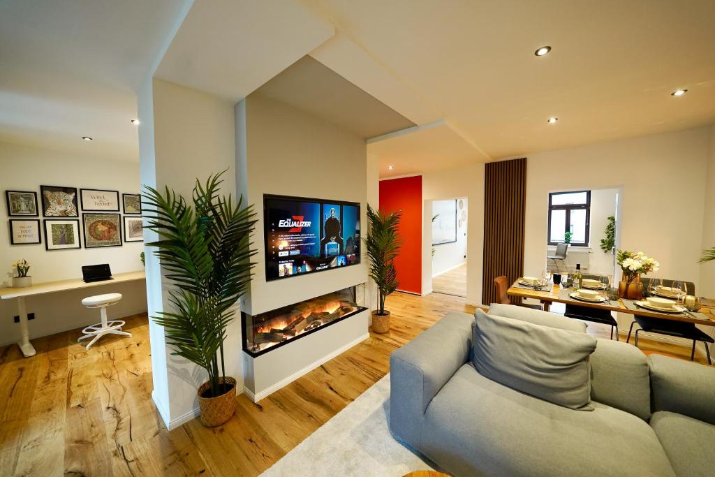 a living room with a couch and a fireplace at EDLER WOHNRAUM Einmalige 140 qm mit Kamin, Klimaanlage, Kaffeevollautomat, Netflix, 2 Balkonen & 2 Tiefgaragenplätzen in Chemnitz