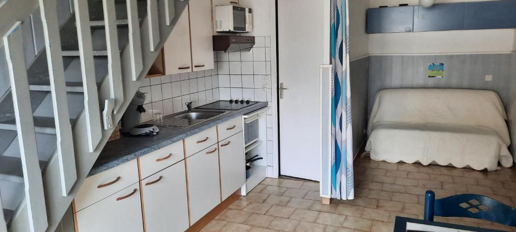 une petite cuisine avec un évier et un escalier dans l&#39;établissement Maison de la plage, à Valras-Plage