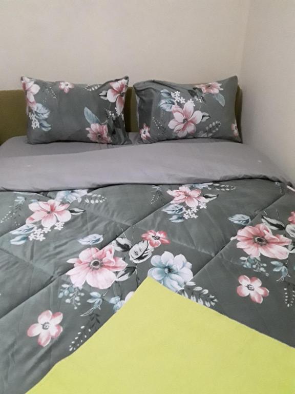 a bed with pink and gray flowers on it at Addis Joy Guesthouse in Addis Ababa