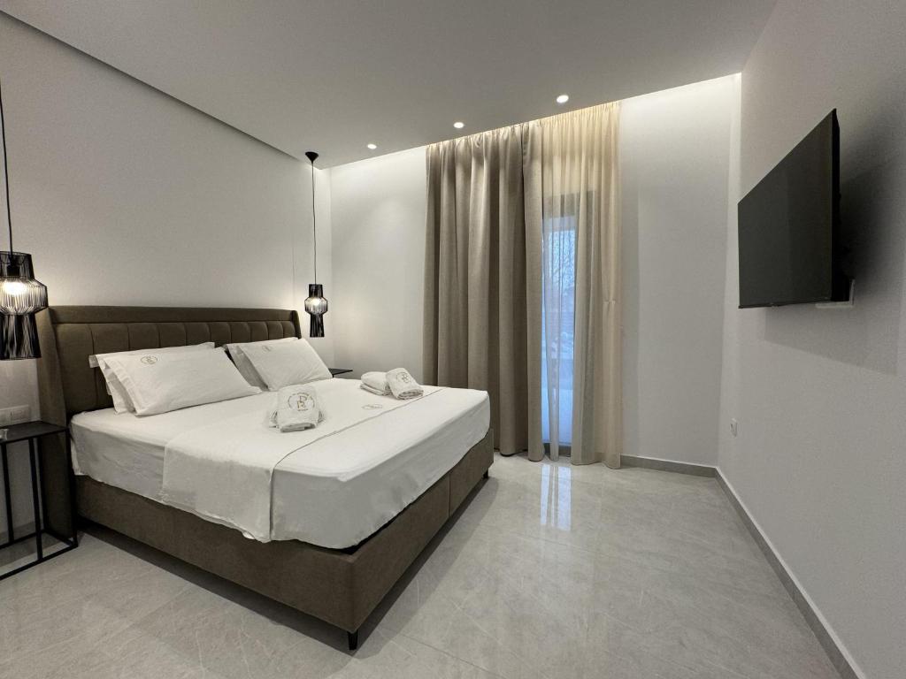 Platinum River Apartments في Potamós: غرفة نوم بسرير وتلفزيون بشاشة مسطحة