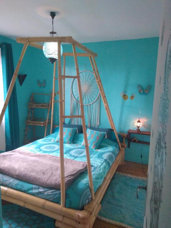 ein Schlafzimmer mit einem Etagenbett aus Holz mit blauen Wänden in der Unterkunft Les gîtes du Poten'ciel, idéal famille, Bien-être, Massages in Allègre