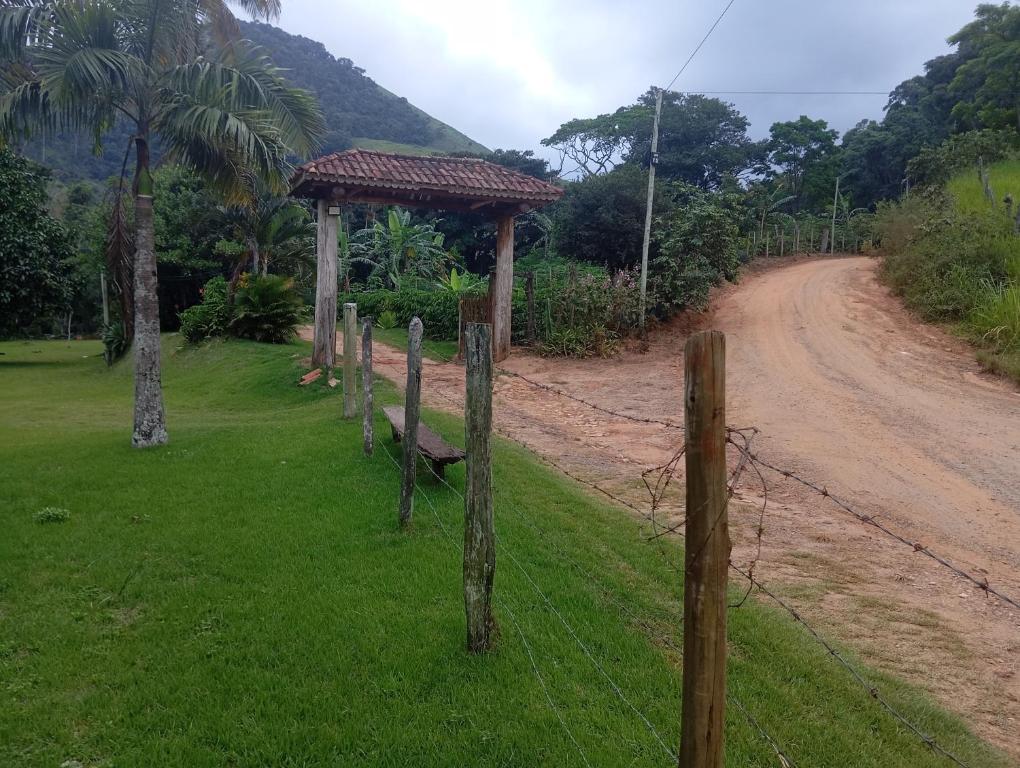 a fence on the side of a dirt road at Camping Casa Velha in Guarapari