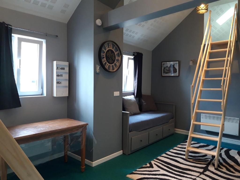 Zimmer mit einer Leiter, einem Stuhl und einem Schreibtisch in der Unterkunft Apartement à Theuville-Baigneaux in Theuville