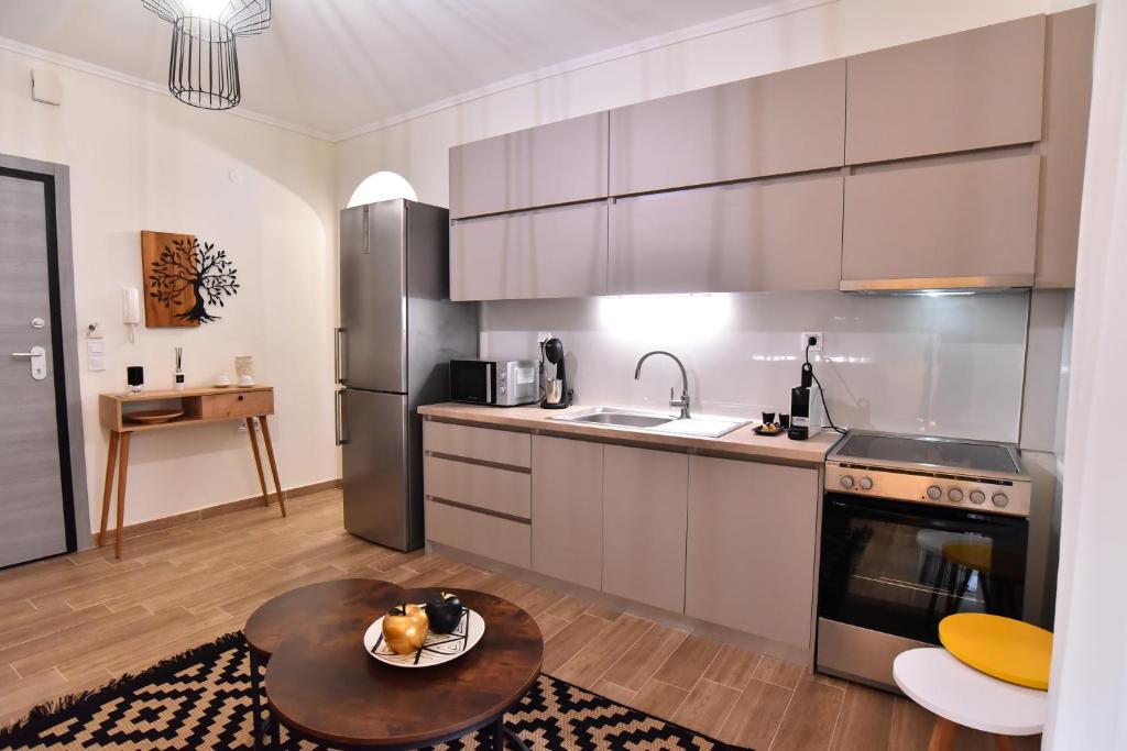 cocina con electrodomésticos de acero inoxidable y mesa en Antoine Apartment, en Nea Peramos