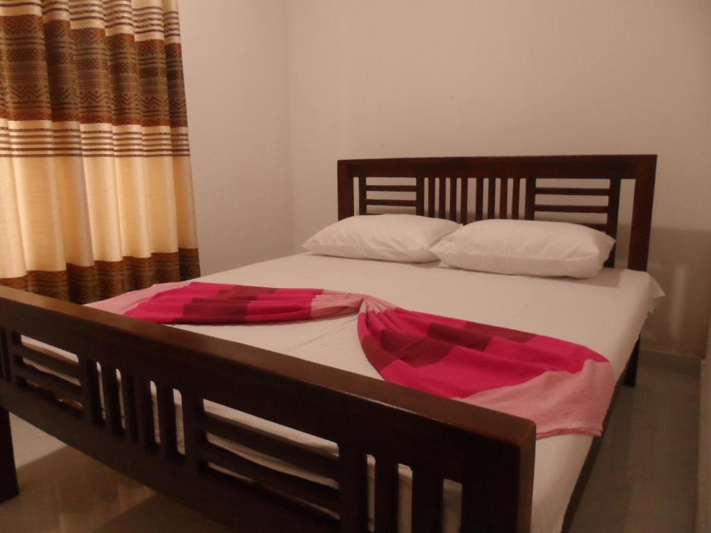 Schlafzimmer mit einem Bett mit weißer und rosafarbener Bettwäsche in der Unterkunft D2 Holiday Inn in Badulla