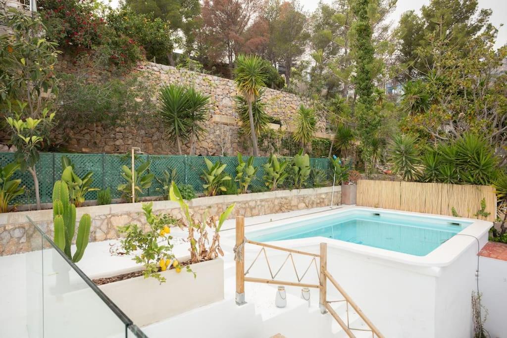 una piscina en un jardín con una valla en Villa glamur en Les Botigues de Sitges 