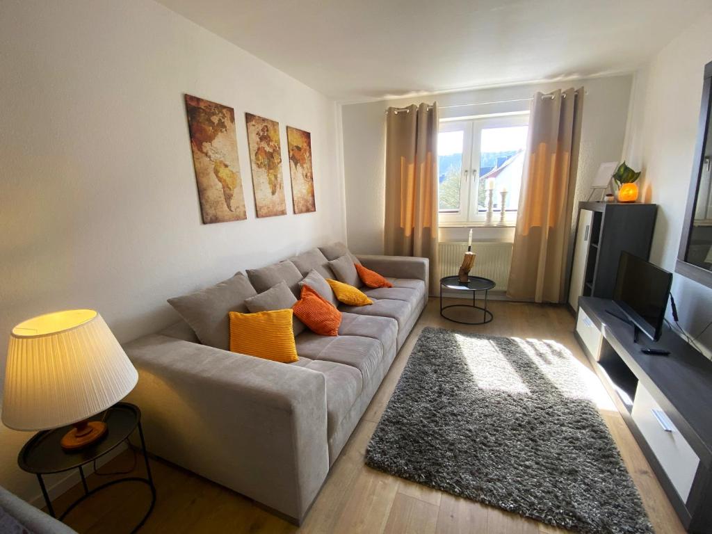 - un salon avec un canapé et une télévision dans l'établissement Schölerberg Apartment mit Tiefgaragenparkplatz und Kingsize-Bett, à Osnabrück
