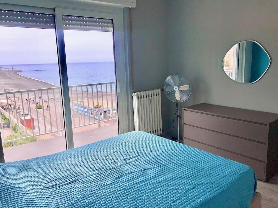 een slaapkamer met een bed en uitzicht op de oceaan bij Appartamento sul mare (Ventimiglia/Bordighera) in Vallecrosia