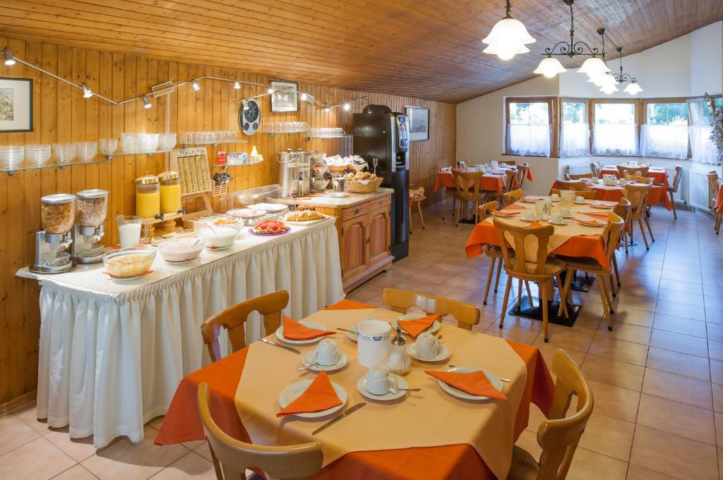 a restaurant with tables and chairs and a kitchen at Hotel Tautermann in Innsbruck