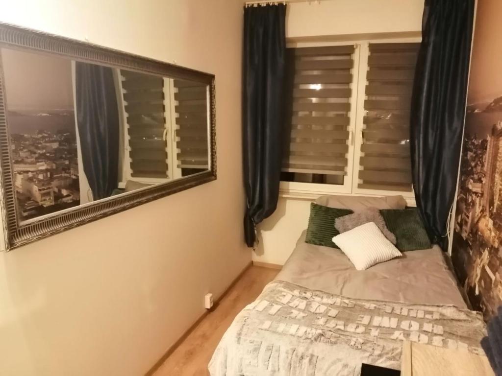 a bedroom with a bed and a mirror at Apartamenty na doby in Siedlce