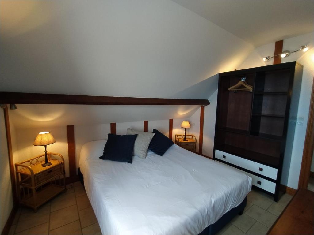 - une chambre avec un lit, 2 lampes et une télévision dans l'établissement Gîtes en Normandie en FRONT DE MER à Asnelles , 3km d'Arromanches, 10km de Bayeux, à Asnelles