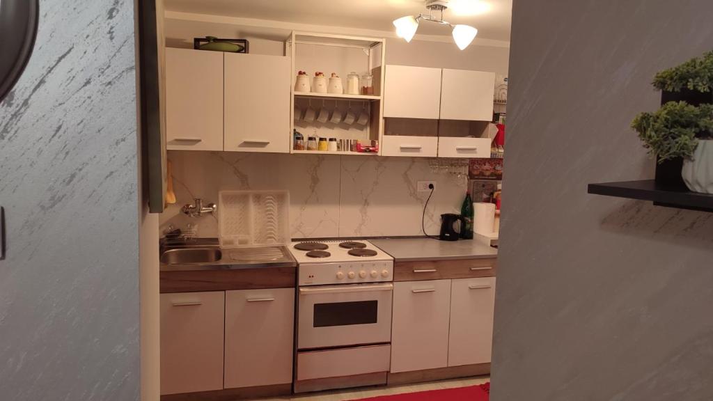 a kitchen with white cabinets and a stove top oven at Za uzivanje u miru in Priboj