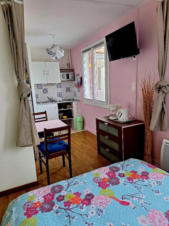 une chambre avec un lit et une table et une cuisine dans l'établissement Studio tout confort à 300 m des thermes, à Cazaubon