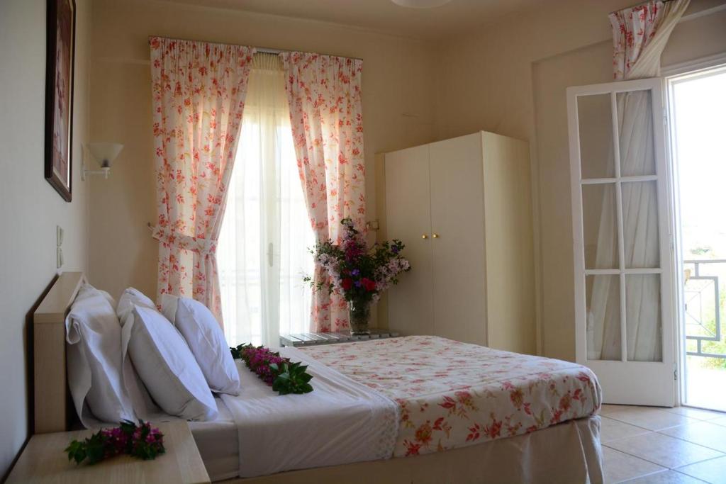 a bedroom with a large bed with a window at Starlight Hotel in Skala