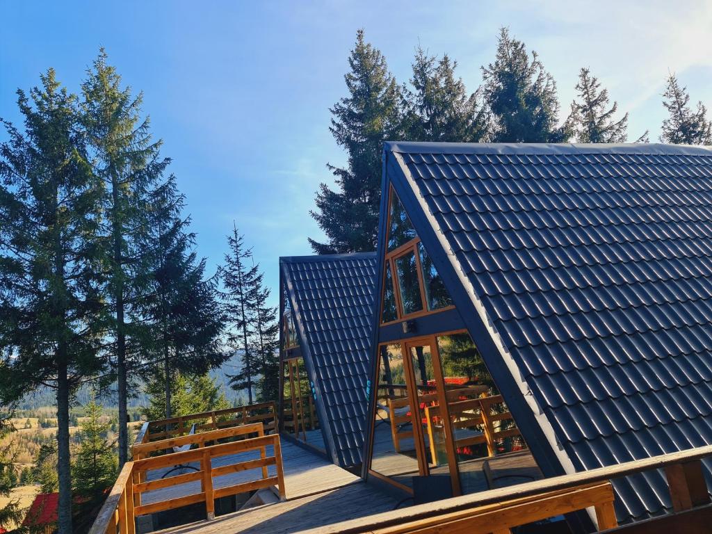 una casa con paneles solares en el techo en Cabane A-frame CeziAde Tihuta, en Piatra Fântânele