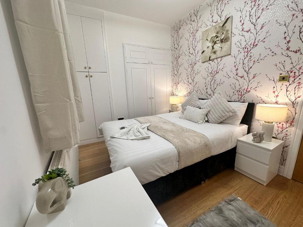 a small bedroom with a white bed and pink wallpaper at 2 Bedroom Apartment In Central London in London