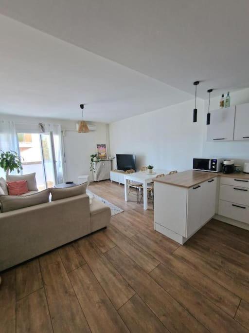 une cuisine et un salon avec un canapé et une table dans l'établissement Appartement cosy à 5 min des plages, à Hyères