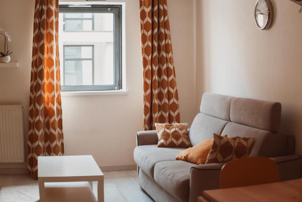 a living room with a couch and a window at Bel appartement au calme avec parking in Lyon