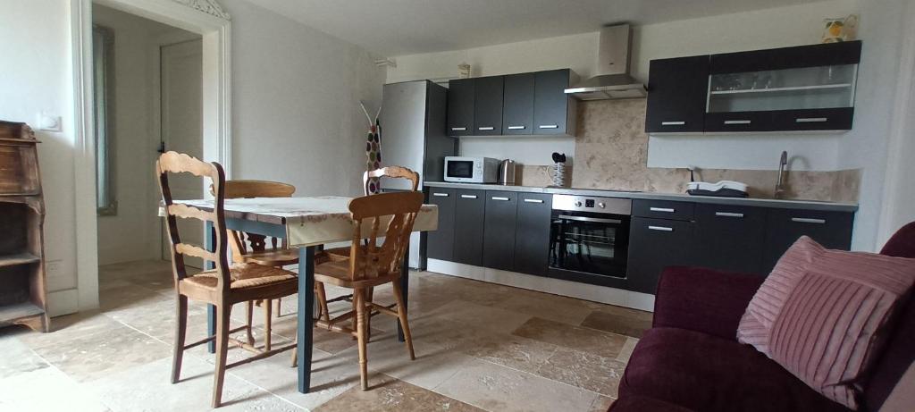 une cuisine avec une table et des chaises dans une pièce dans l'établissement Countryside Annexe with private garden, à La Sauvetat-du-Dropt