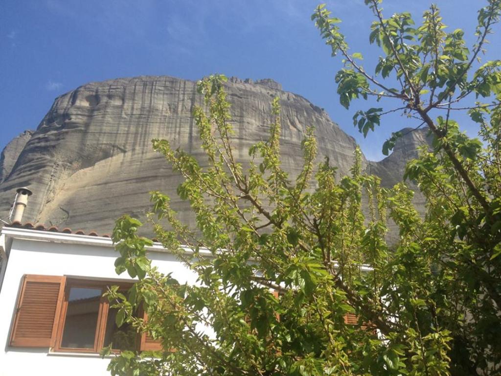 une maison en face d'un grand rocher dans l'établissement Pirinas Meteora, à Kalambaka