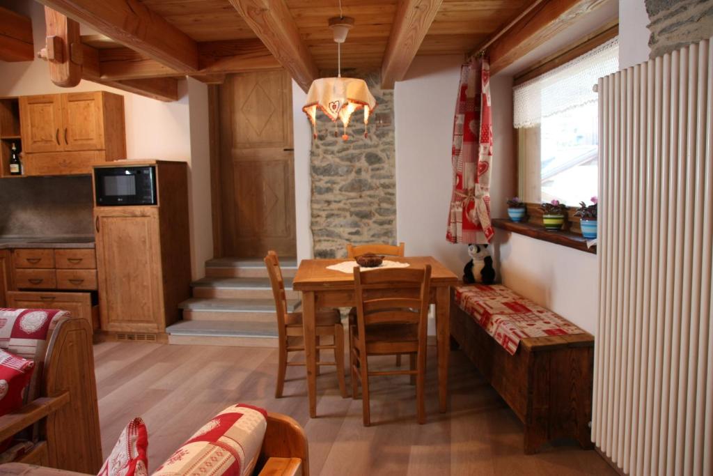 a kitchen and dining room with a table and chairs at Lo Trapei in Aosta