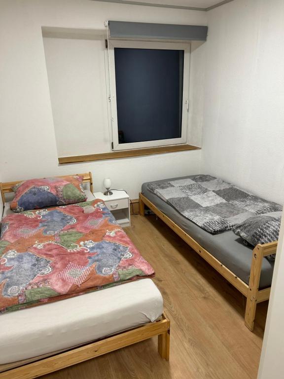 twee bedden in een kamer met een raam bij Ferienwohnung Kotsch in Engen