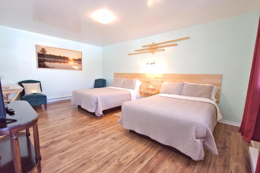 a hotel room with two beds and a table at Jacques Cartier Motel in Sydney