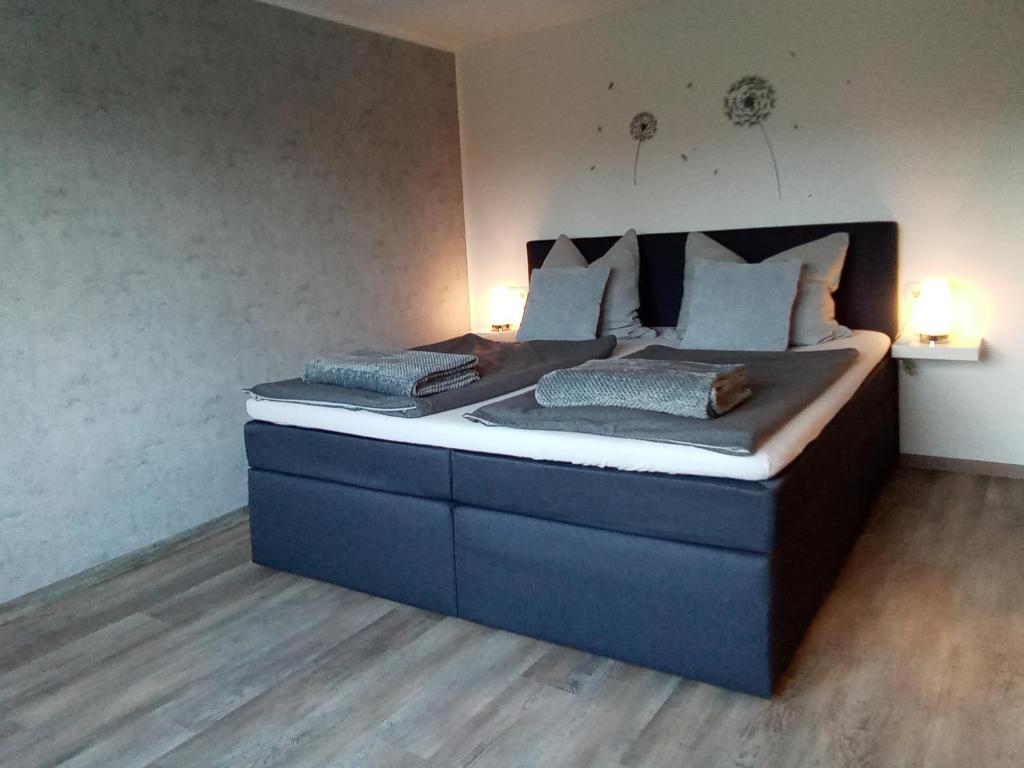 uma cama grande num quarto com duas lâmpadas em Bergblick em Thale