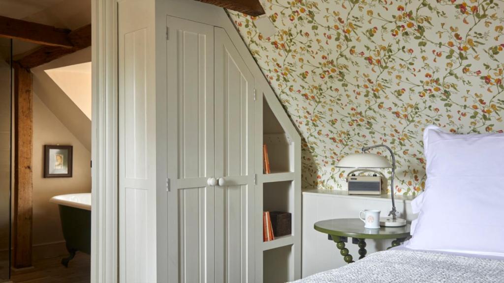 a bedroom with a bed and a wall with flowers at The George In Rye in Rye
