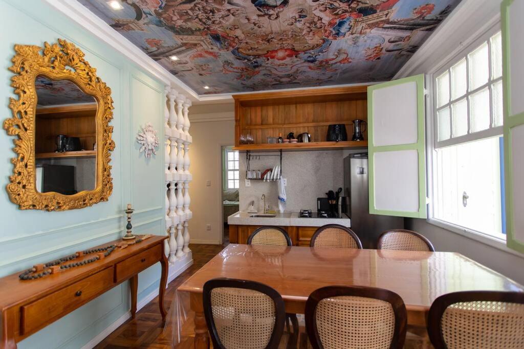 a dining room with a table and a mirror at Casa Fé - Caminhos de Ouro Preto in Ouro Preto
